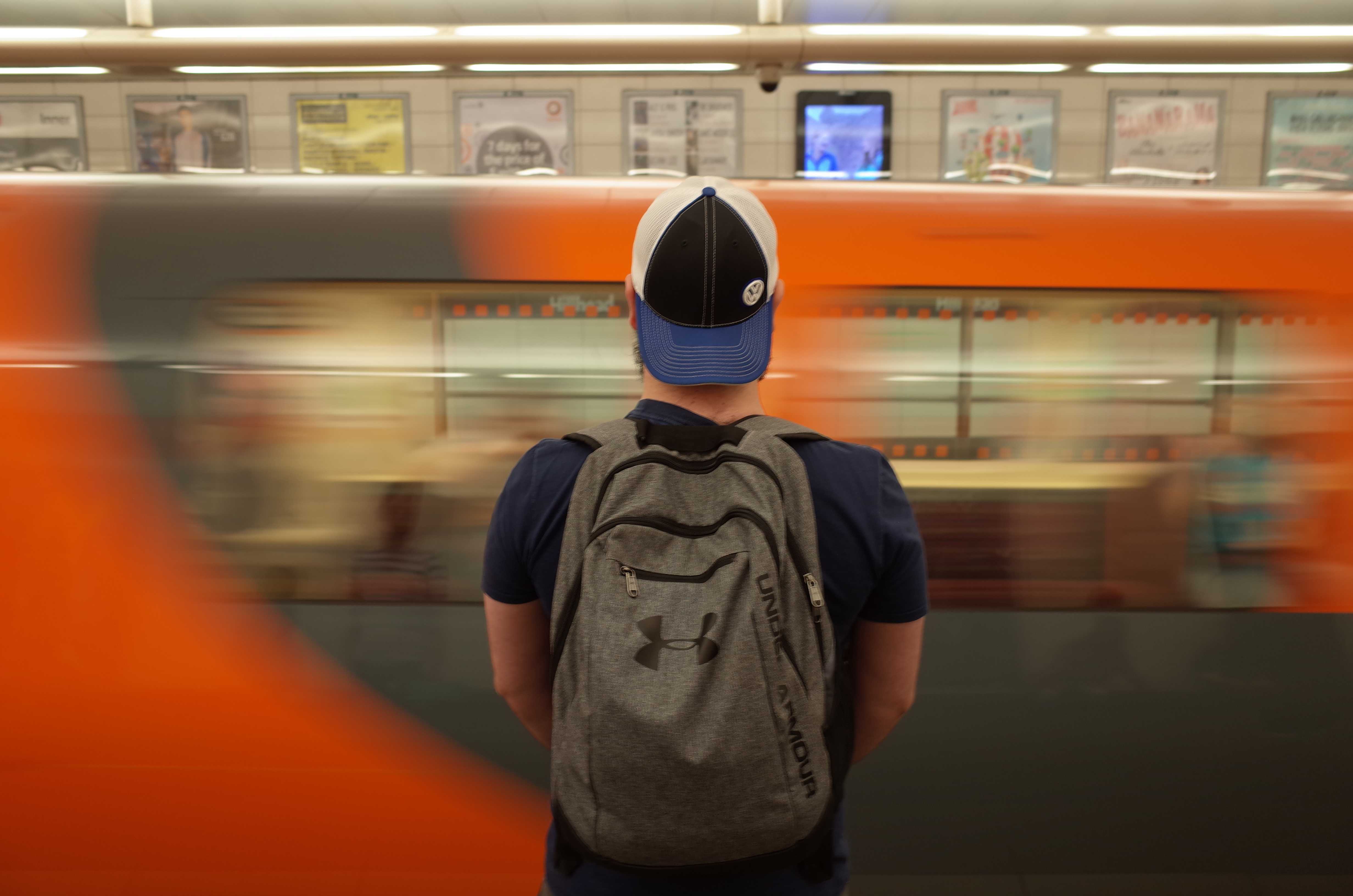 young man with a backwards baseball cap waiting in the Glasgow subway station underground