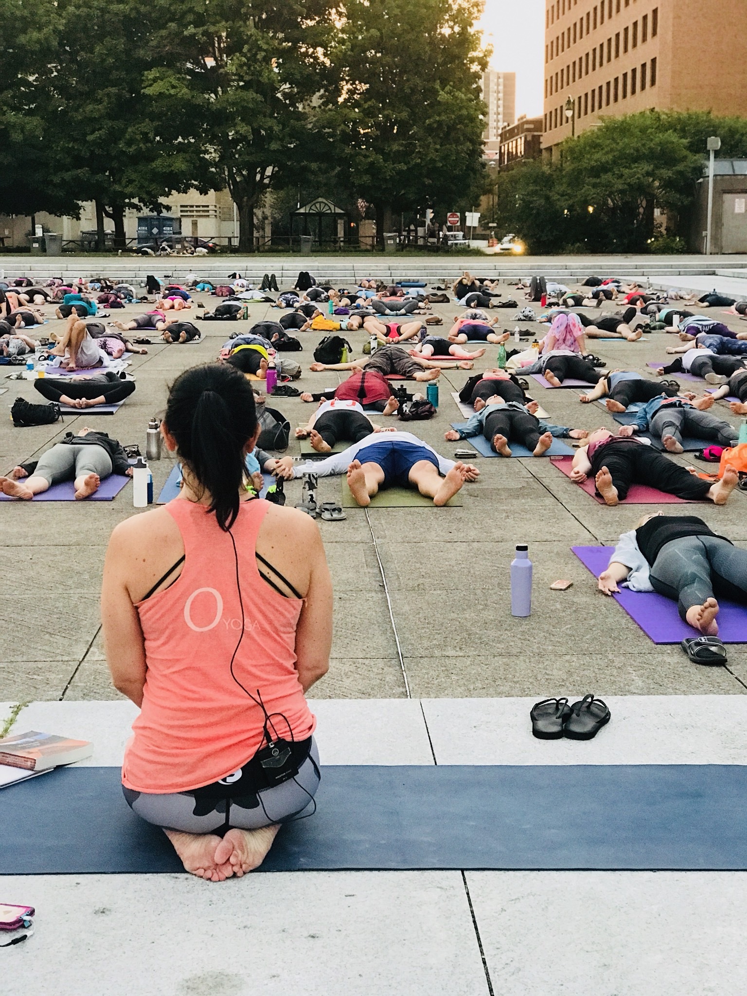 Tiffany Cagwin leading an outdoor yoga session in a city